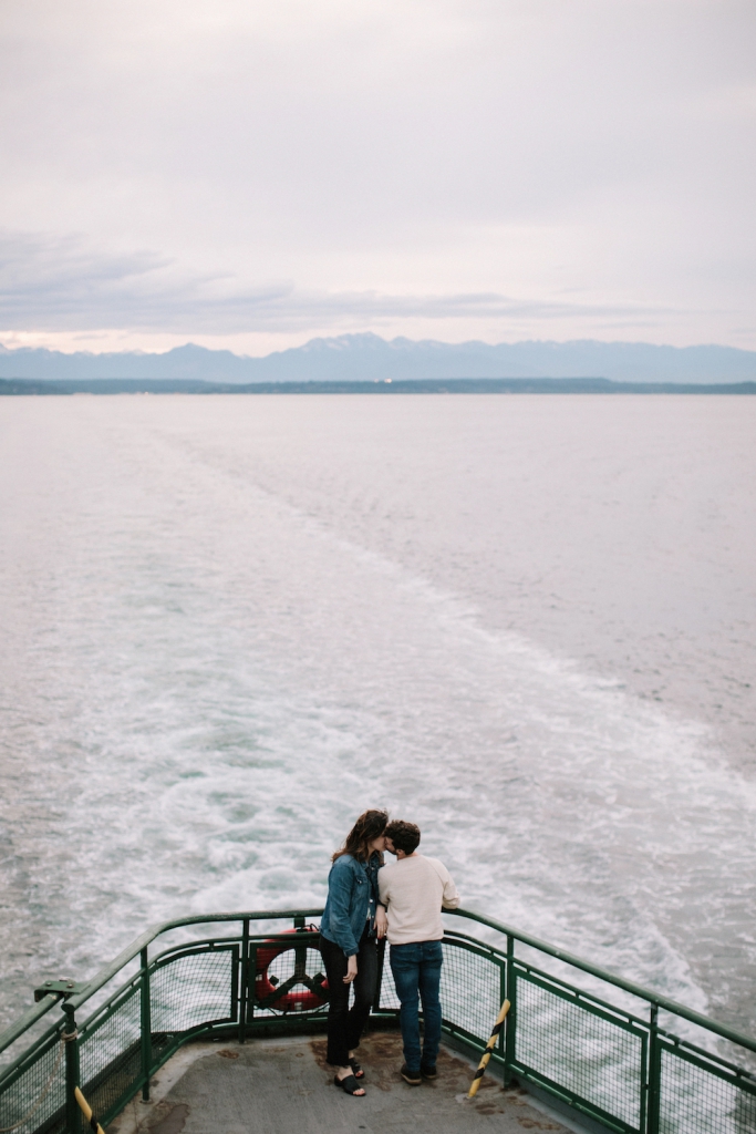 couple kissing on the seattle ferry with sweeping views of the water and mountains