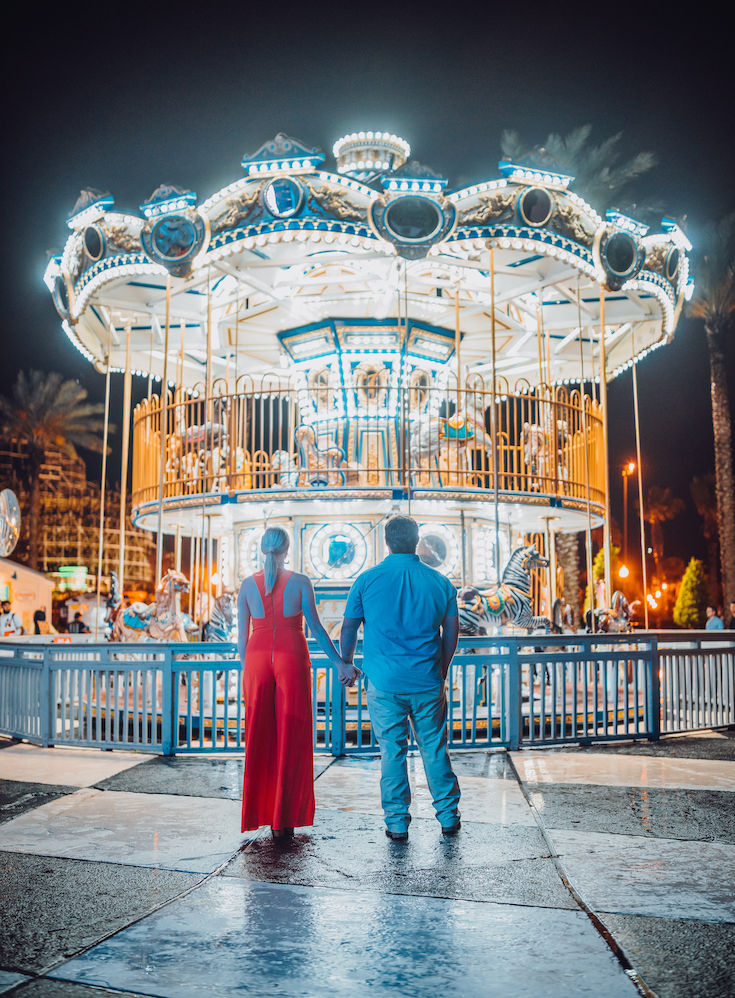 man and woman holding hands at kemah boardwalk in houston