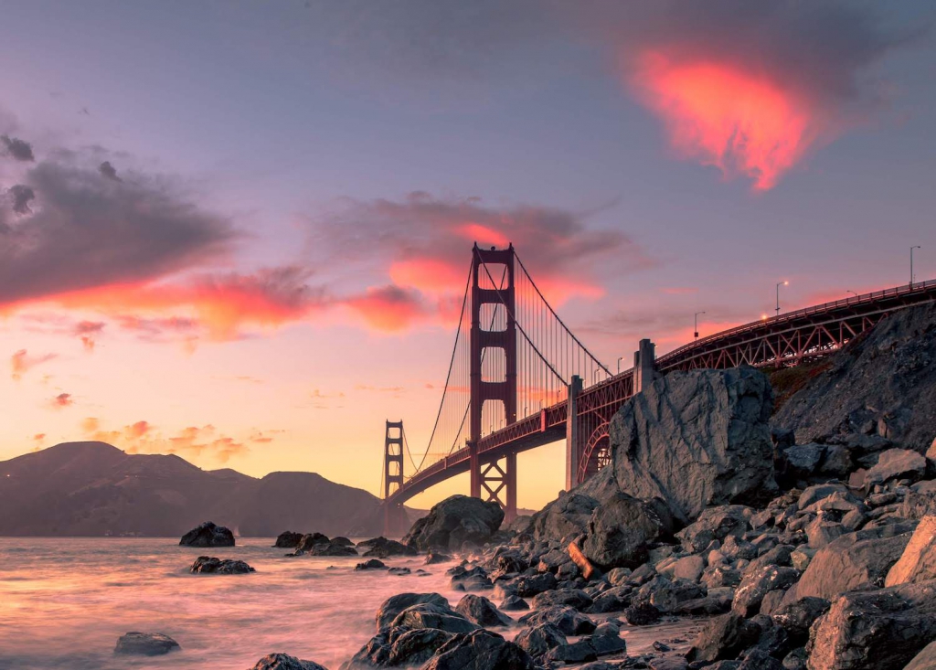 baker beach in san francisco, california with the golden gate bridge in the background at sunset