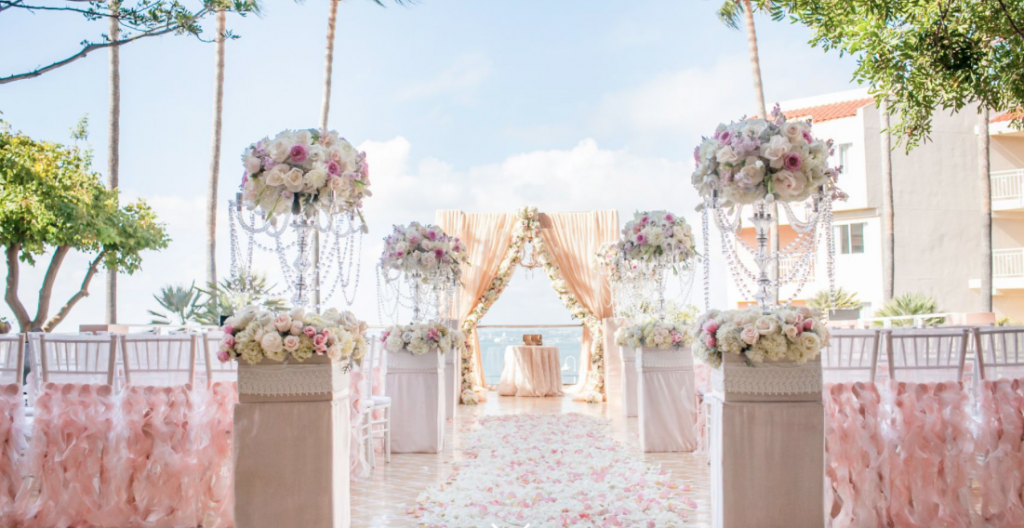 an outdoor setup for a wedding ceremony at loews coronado bay resort with pink and white flowers and chairs
