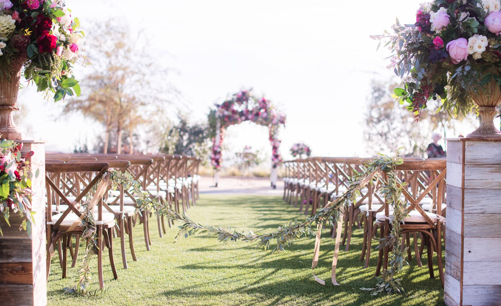 a flower-covered arch and chairs set up on a manicured lawn for a wedding at sheraton carlsbad resort & spa