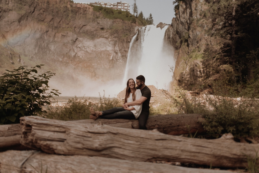couple embracing at snoqualmie falls in seattle with waterfall in the background