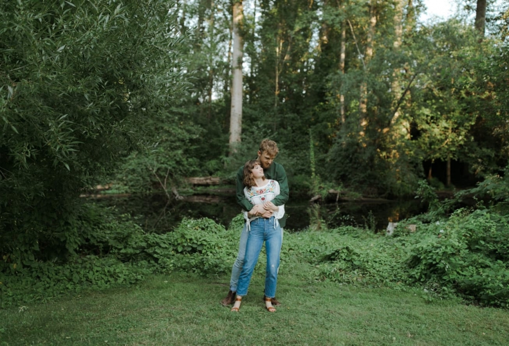 couple embracing at washington park arboretum in seattle surrounded by foliage