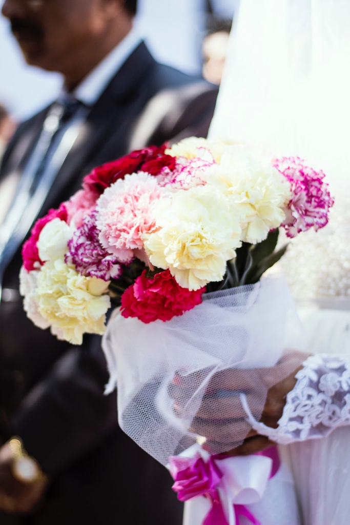 bride holding bouquet of carnations