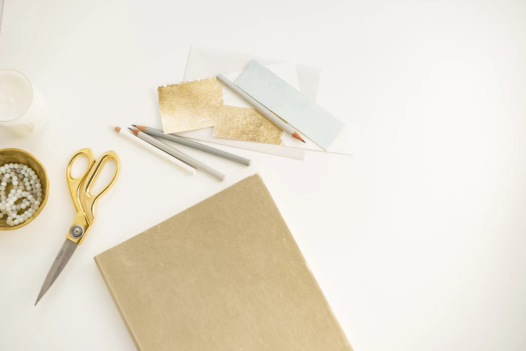 When to send save the dates: Gold stationary, gold scissors, and colored pencils 