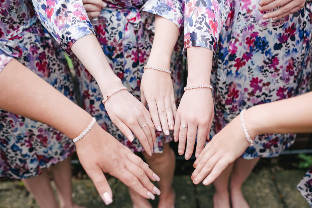 Close-up photo of bridesmaids arms with matching bracelets