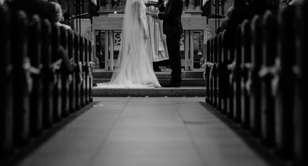 Wedding ceremony script: Black and white photo of couple at the church altar